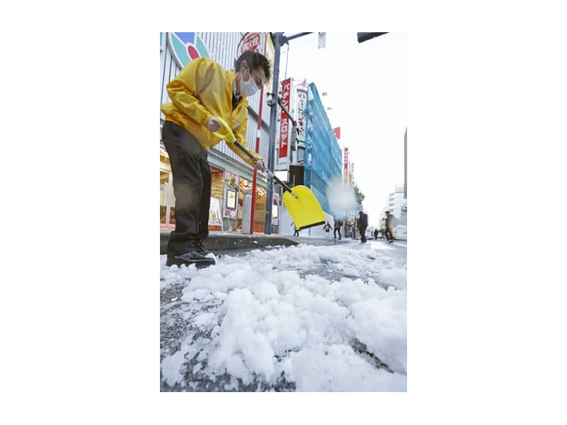 まとまった積雪から一夜明け、道路の除雪作業をする人たち＝7日午前、東京・新橋