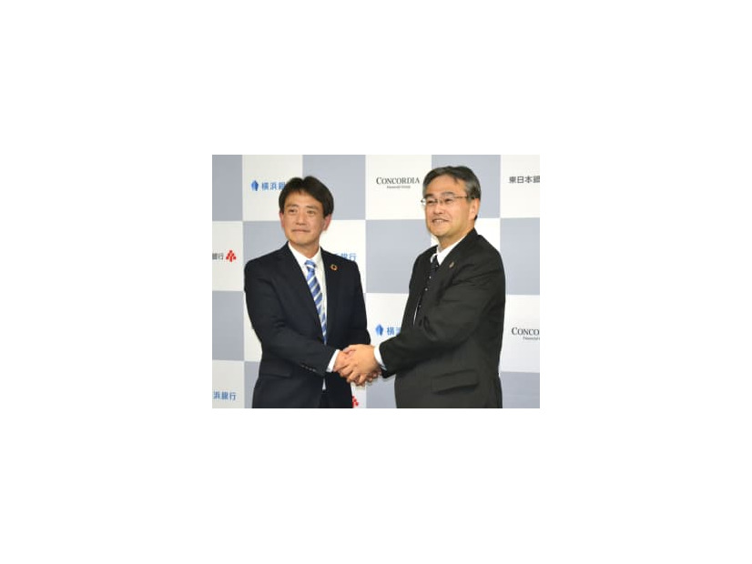 コンコルディアFGの大矢恭好社長（右）の後任に決まり、握手する片岡達也氏＝22日午後、横浜市