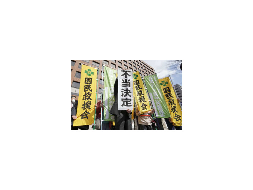 再審開始を認めない決定に、名古屋高裁前で「不当決定」と書かれた紙を掲げる弁護士＝3日午前