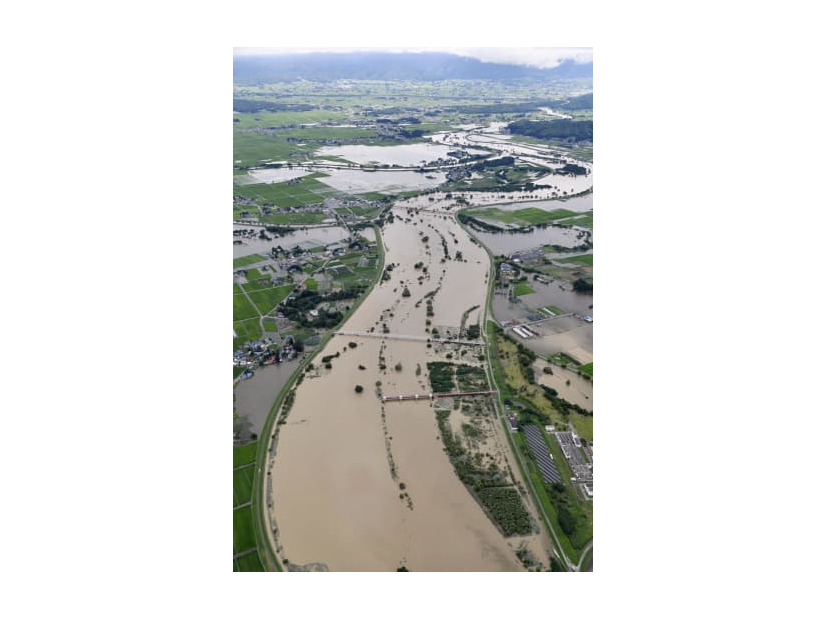 大雨の影響で増水した、山形県の南陽市（右側）と川西町を流れる最上川＝4日午後2時10分（共同通信社機から）