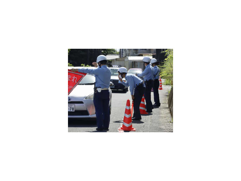 女児が置き去りにされた駐車場付近で検問を実施し、情報提供を求める静岡県警の捜査員＝12日午前、静岡県牧之原市