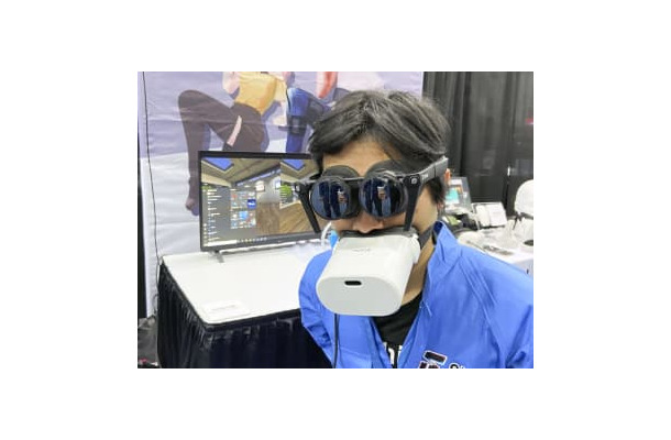 仮想現実（VR）対応端末を装着して来場者に説明するパナソニックの子会社シフトールの岩佐琢磨CEO＝3日、米ラスベガス（共同）