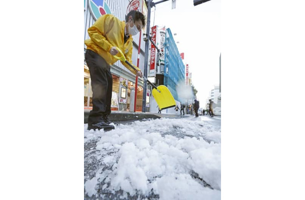 まとまった積雪から一夜明け、道路の除雪作業をする人たち＝7日午前、東京・新橋