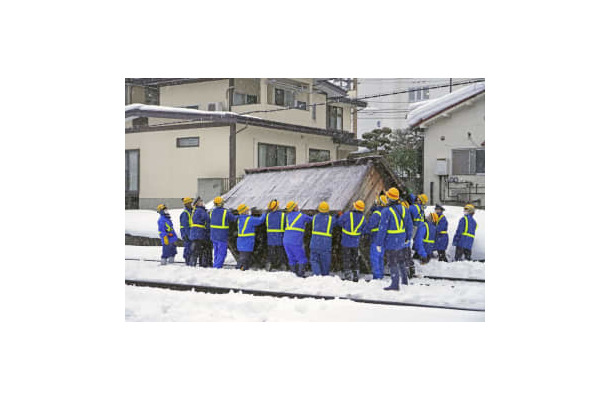 線路に滑り落ちた小屋を撤去する作業員ら＝3日午後4時40分ごろ、山形市