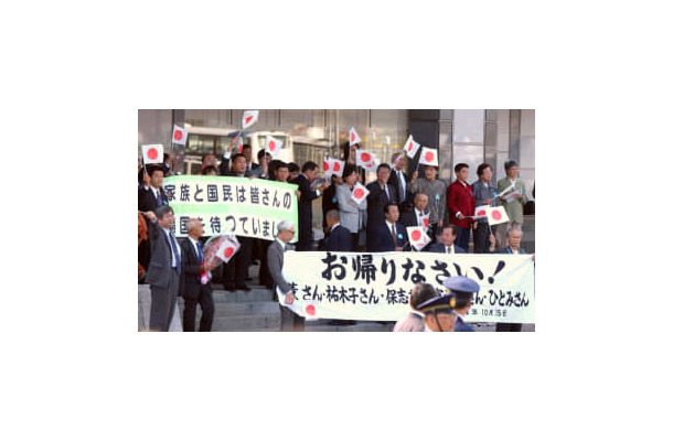 拉致被害者5人を乗せて到着した政府チャーター機に向かい手を振る出迎えの家族ら＝2002年10月、羽田空港