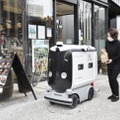 弁当を配達ロボットに入れる店員＝25日午前、東京・大手町