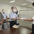 広島県の担当者に住民監査請求書を手渡す山田延広弁護士（左）ら＝5日午後、広島県庁